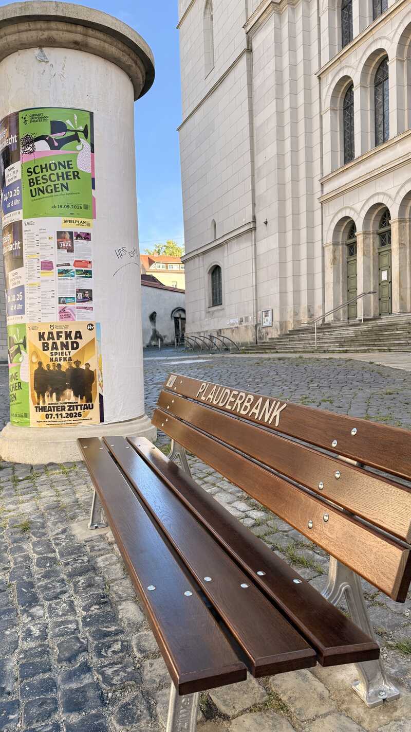 Die neue Plauderbank neben der Litfa&szlig;s&auml;ule vor der Johanniskirche