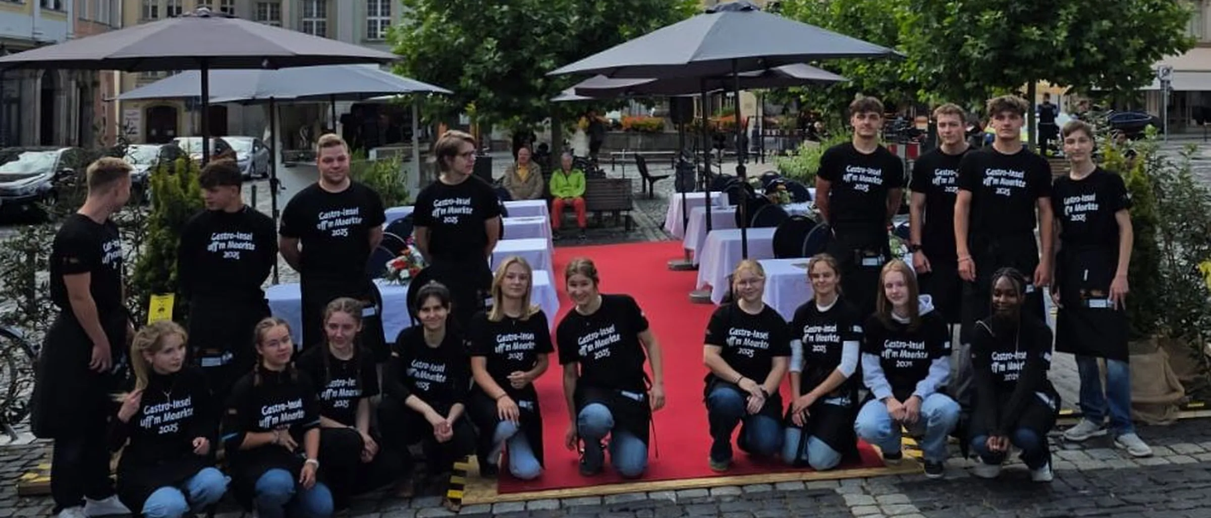 Schülerinnen und Schüler stehen auf dem Marktplatz vor ihrem Gastronomieareal