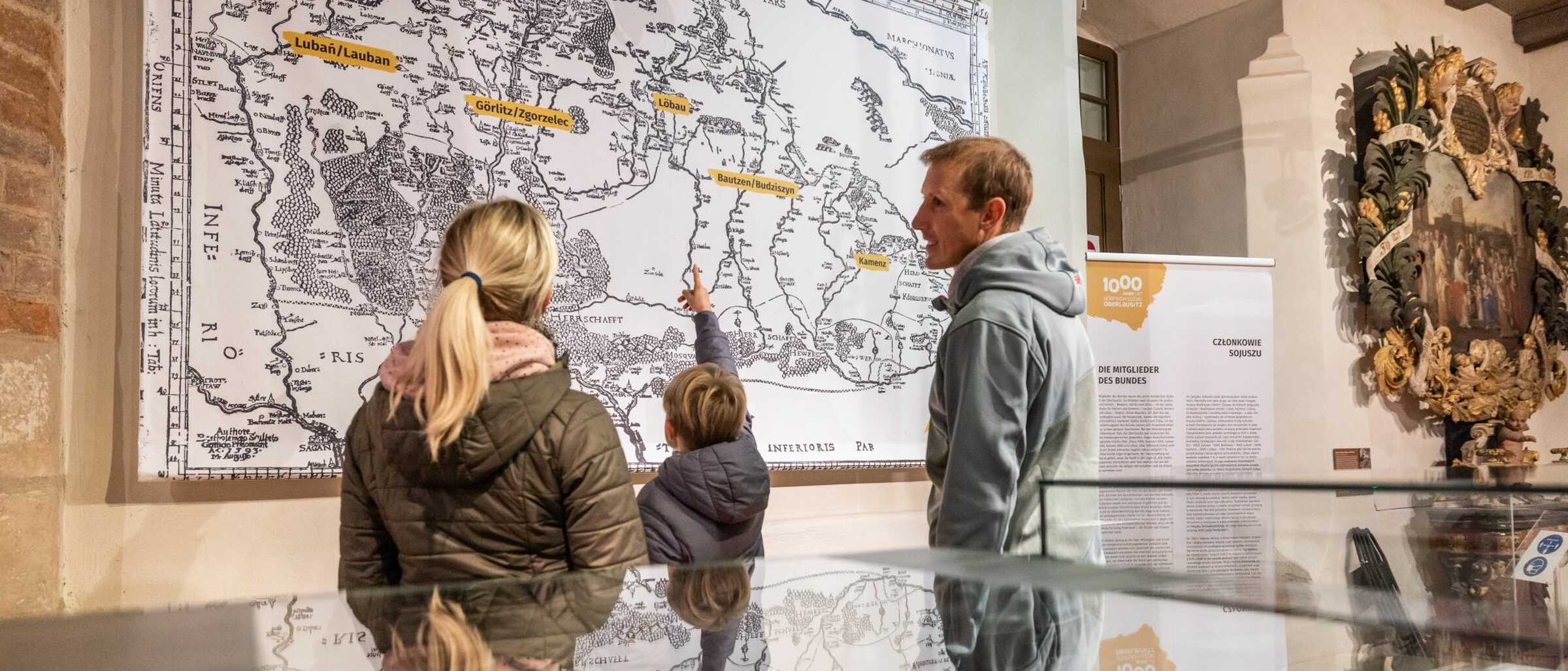 Familie im Stadtmuseum vor der alten Karte des Sechsstädtebundes