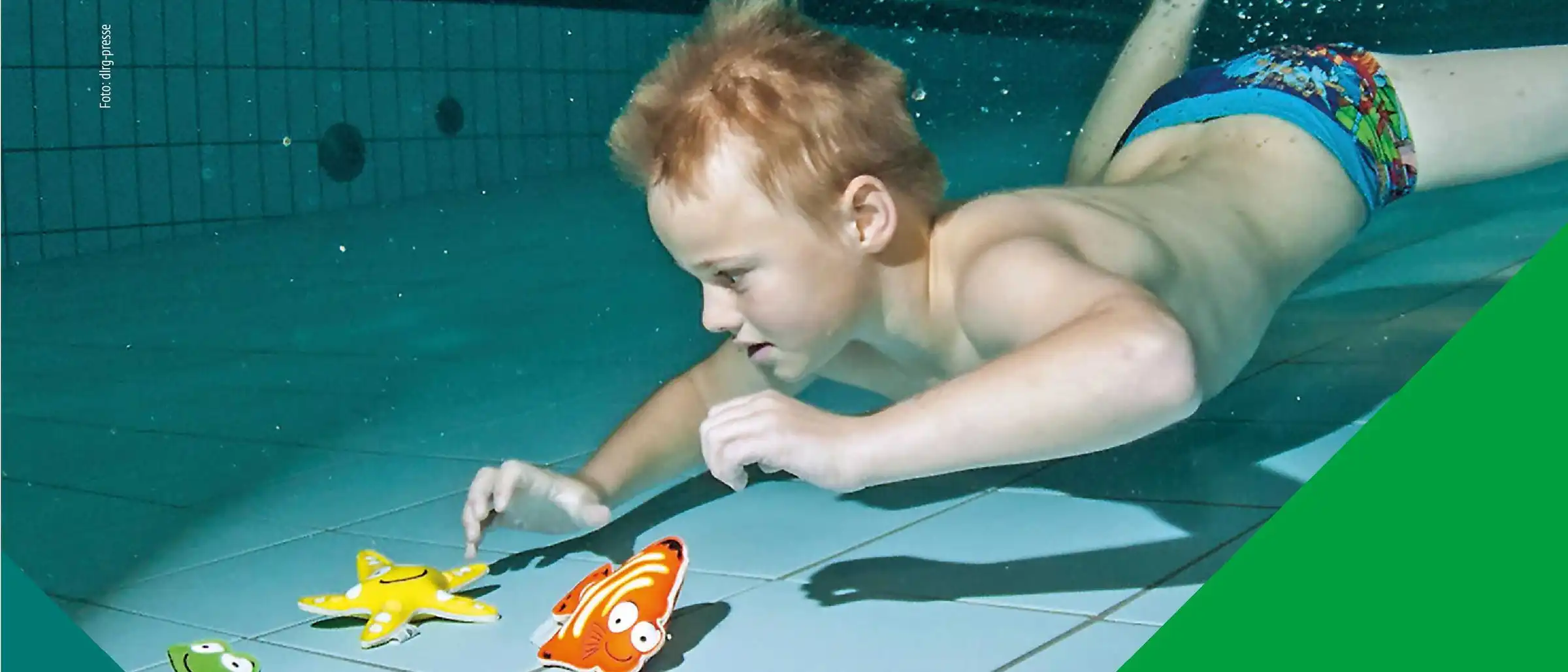 Einladung zum Deutschen Schwimmabzeichentag. Zu sehen ist ein Junge, der in einem Becken nach Spielzeug taucht.
