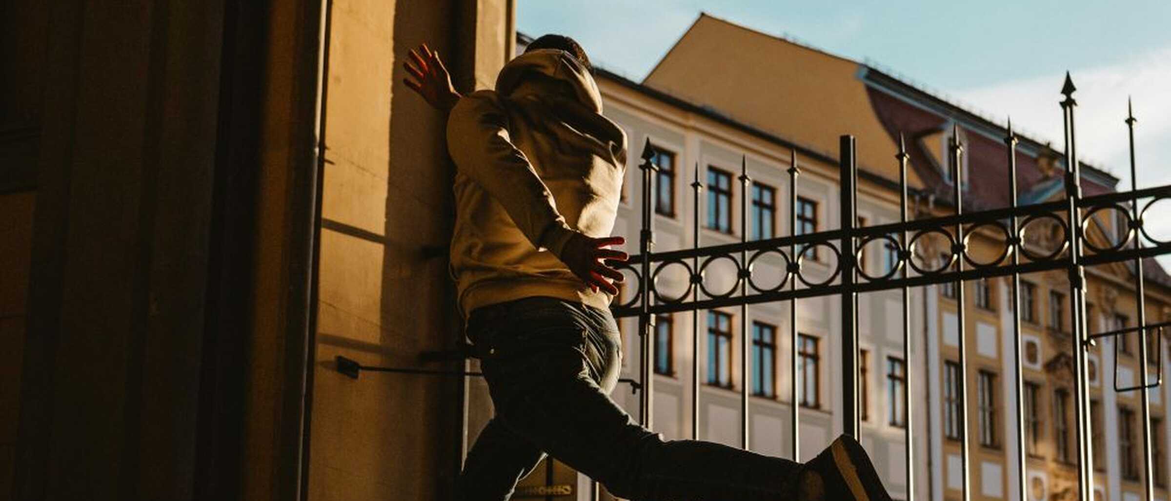 Ein junger Mann springt im Rathaus-Eingan in Zittau in die Höhe und wird in diesem Moment fotografiert