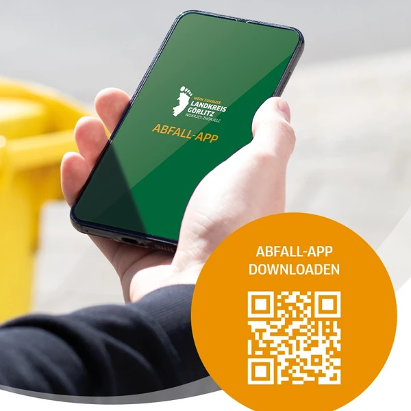 eine Hand h&auml;lt ein Smartphone auf dem der Startbildschirm der Abfall-App zu lesen ist